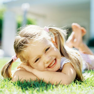 girl-in-piggytails-laying-on-grass-sq-300